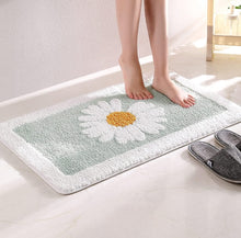 Load image into Gallery viewer, Person stepping onto a floral bath mat with a daisy design.
