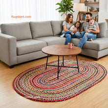 Load image into Gallery viewer, Family sitting on a gray sectional sofa with a colorful round rug in front