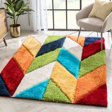 Load image into Gallery viewer, A multicolored shaggy carpet with a geometric pattern featuring various colors such as red, blue, green, yellow, and orange, placed on a white floor in a room with a chair and a window.
