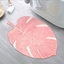Load image into Gallery viewer, Pink leaf-shaped rug on a gray floor next to a white bathtub.
