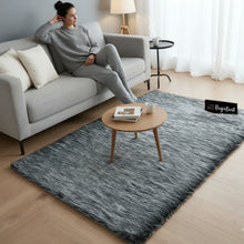 Load image into Gallery viewer, Woman sitting on a gray sofa with a textured gray rug in a living room.
