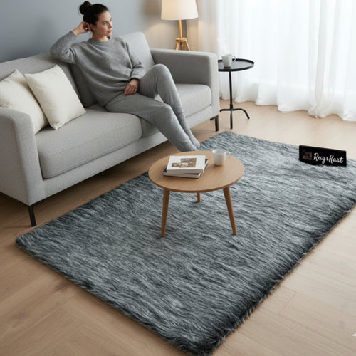 Woman sitting on a gray sofa with a textured gray rug in a living room.