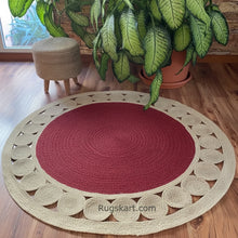Load image into Gallery viewer, Round red and beige rug on a wooden floor with plants and a stool in the background.

