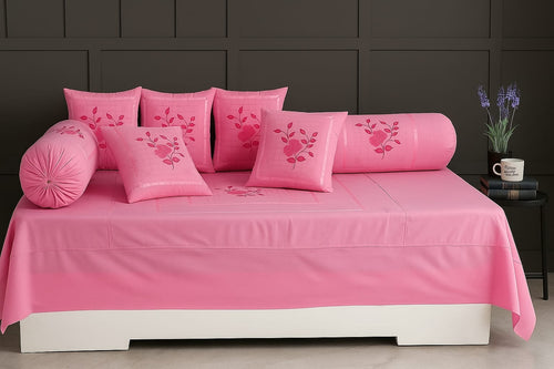 Pink bedroom set with matching bedding and pillows on a bed.